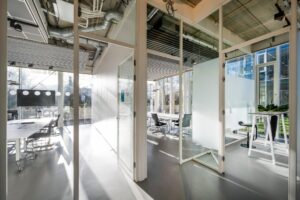 Moderne glazen vergaderruimtes met strak interieur aan de Fred. Roeskestraat, badend in natuurlijk daglicht.